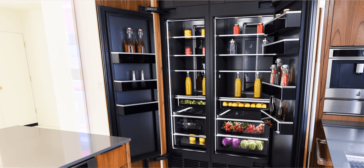 A JennAir Column Refrigerator in a bright kitchen with modern wood cabinetry. 